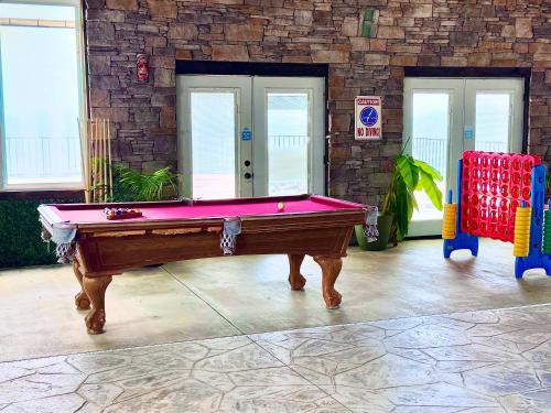 a pool table in a room with two chairs at critter corner at Grant Summit Cabins in Bryant