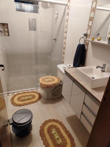 a bathroom with a shower and a toilet and a sink at Kitnet in Araucária