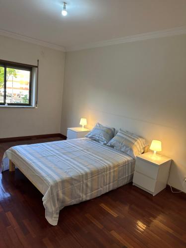 a bedroom with a bed and two night stands with lamps at Casa Flores in Amora