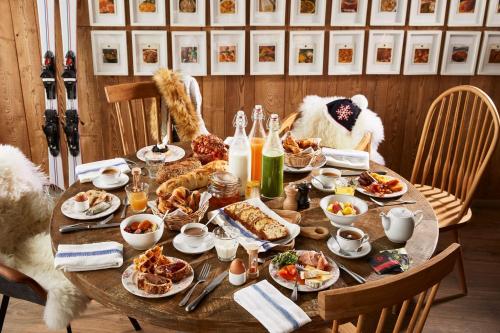 a table with breakfast foods and drinks on it at Ecrin Blanc Resort Courchevel - Aquapark in Courchevel