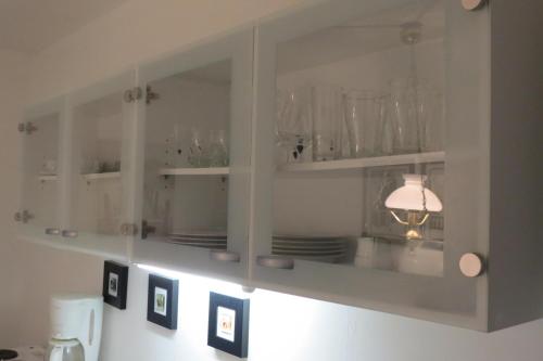 a kitchen cabinet with glasses and plates on it at Country Dream - Langholt 2 in Selfoss