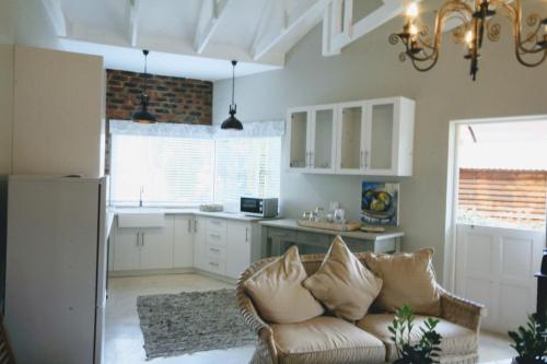 a living room with a couch and a kitchen at Maryah House in Pretoria