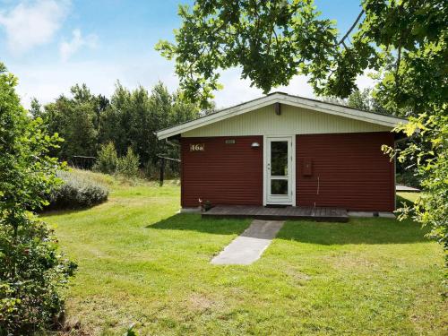 a small red house with a grass yard at Cozy Beach Retreat - By Traum Ferienwohnungen in Ålbæk
