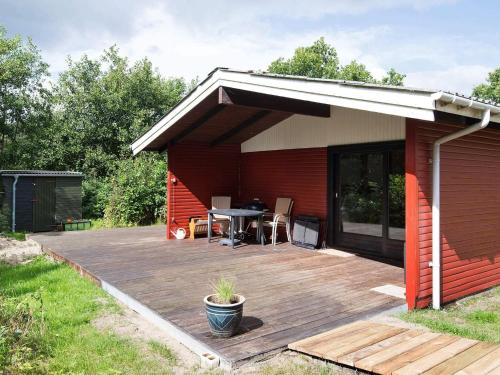 a red house with a deck and a table at Cozy Beach Retreat - By Traum Ferienwohnungen in Ålbæk