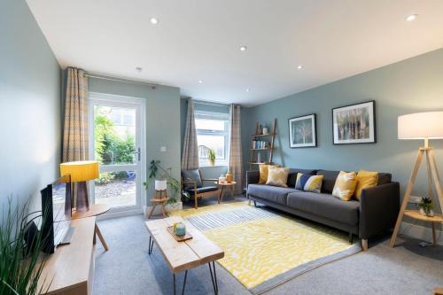 a living room with a couch and a table at Peaceful & Spacious 2 Bed Home in Cheltenham in Gloucestershire