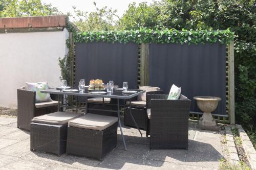 une table et des chaises dans un jardin avec une clôture dans l'établissement Peaceful 3-Bed Cottage in Eastington, à Claypits