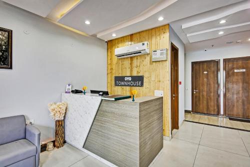 a lobby with a counter with a sign on the wall at Townhouse Golden Frame near sec 62 noida in Ghaziabad