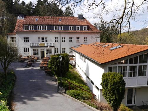 a large white building with a red roof at Haus Honigstal Landhaus Café in Wuppertal