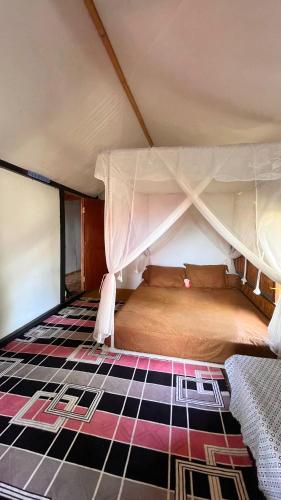 a bedroom with a canopy bed with a checkered floor at Davi homestay in Sumbawa Besar