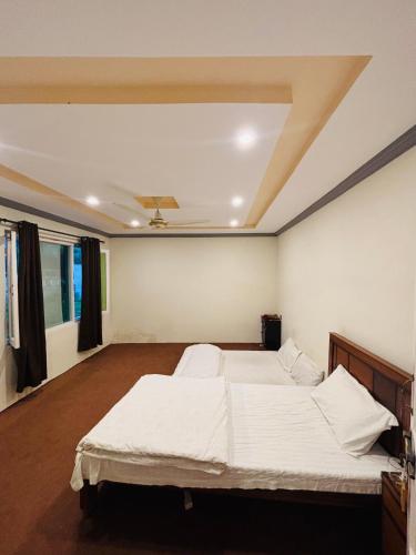 a bedroom with a large white bed in it at Aba-SHAH GUEST HOUSE SKARDU in Skardu