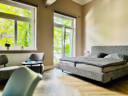 a bedroom with a bed and two windows at Pension Am Sültebrunnen in Bad Oeynhausen