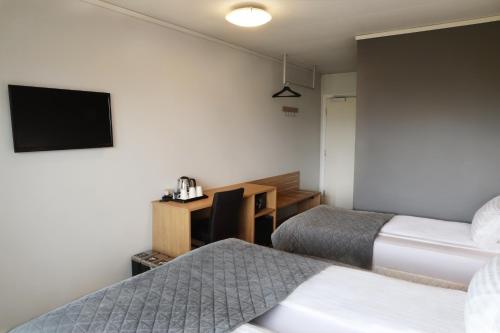 a hotel room with two beds and a desk at Fosshotel Nupar in Kálfafell