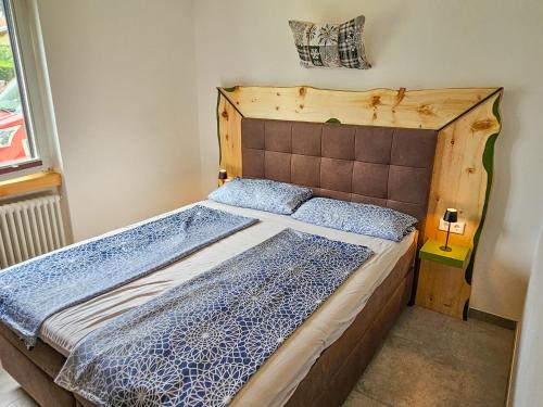a bed with a wooden headboard in a room at Lago Lodge Claudia in Domaso