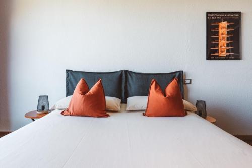 a bed with two orange pillows on top of it at Studiò Pila 1800 in Pila