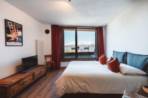 a bedroom with a bed and a tv and a window at Studiò Pila 1800 in Pila