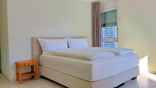 a white bed in a room with a window at Residence la Rochelle in Chalais