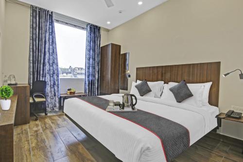 a hotel room with a large bed and a window at Townhouse Golden Frame near sec 62 noida in Ghaziabad