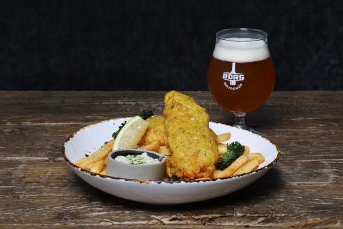 a plate of food with fish and fries and a glass of beer at Fosshotel Nupar in Kálfafell