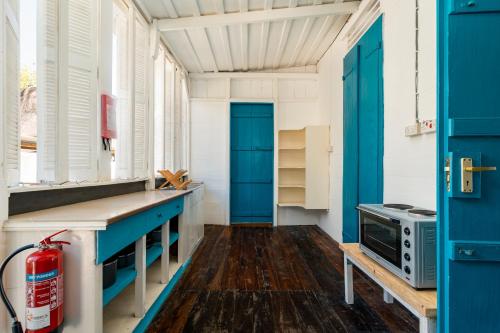 a kitchen with blue doors and wooden floors at Beach House Beau Vallon in Beau Vallon
