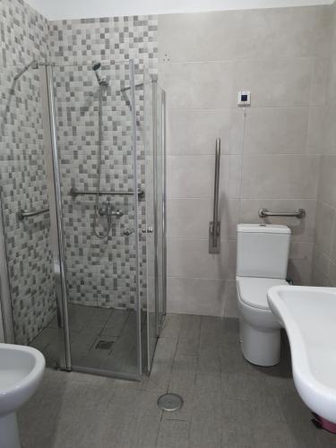 a bathroom with a shower and a toilet and a sink at Alvorada Medieval, AL in Valença