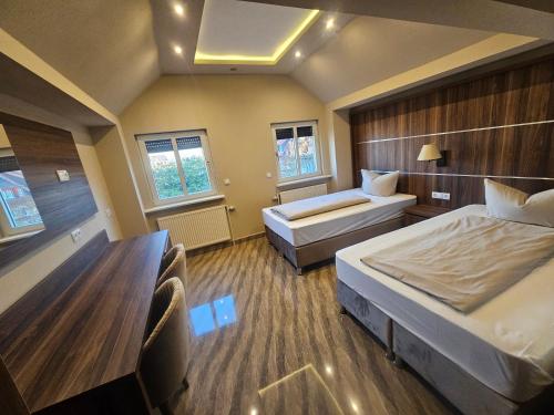 a hotel room with two beds and two chairs at Hotel City Faber in Worms