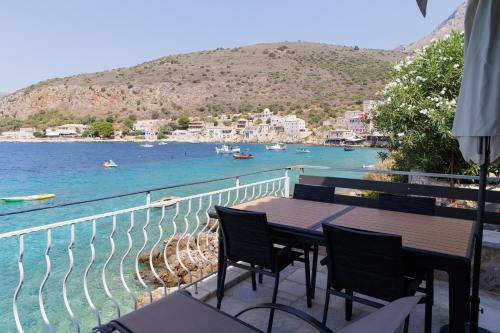 a table and chairs on a balcony overlooking the water at Limeni koilakos Suite in Limeni