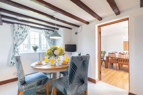 a dining room and living room with a table and chairs at Beautiful Danford House & Lodge with Hot Tub in Hartpury