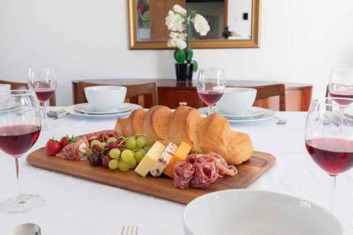 a plate of food on a table with wine glasses at Beautiful Danford House & Lodge with Hot Tub in Hartpury