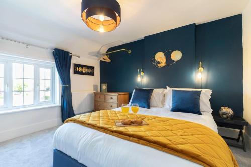 a bedroom with a large bed with a yellow blanket at Beautiful Danford House & Lodge with Hot Tub in Hartpury