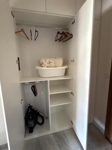 a walk in closet with white cabinets and shelves at Studio Mavis in Kašperské Hory