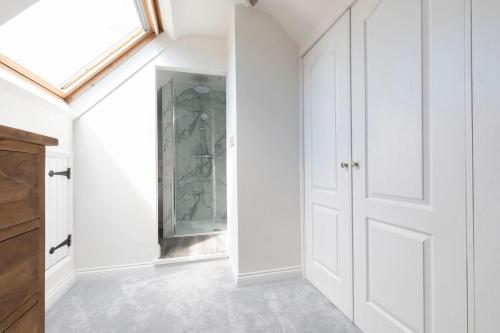 a hallway with a closet with a glass door at Beautiful Danford House & Lodge with Hot Tub in Hartpury