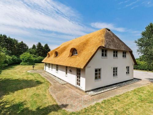 a large white building with a thatched roof at 5 star holiday home in Gram in Gram