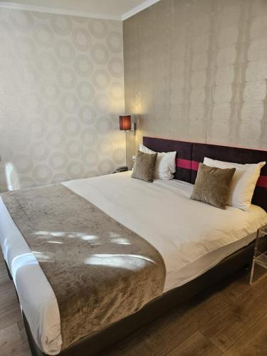 a bedroom with a large bed with white sheets and pillows at ATN Hôtel in Paris