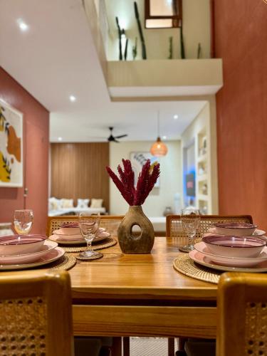 a wooden table with plates and glasses on it at Casa Deva in Uluwatu