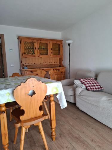 a living room with a table and a couch at Appartamento Sot le Pale in Taibon