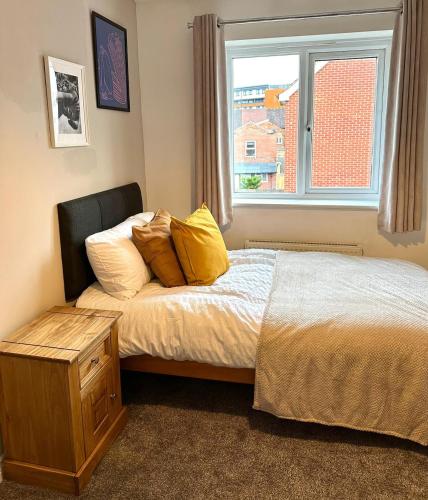 a bed with yellow pillows and a window in a room at Jeremiah Lodge in Fallings Park