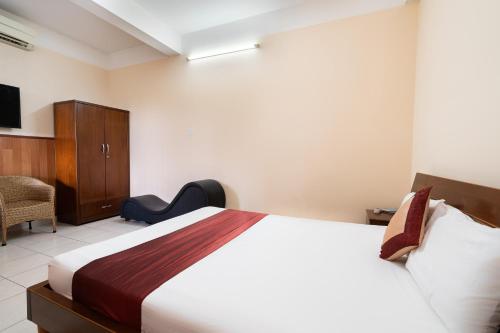 a bedroom with a bed and a cabinet and a tv at Collection O Nam Phuong Hoang Hau Near Lotte Mart in Ho Chi Minh City