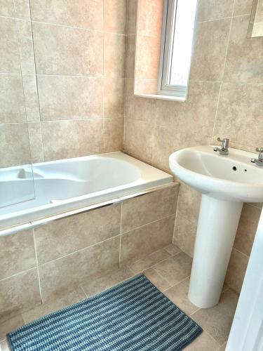 a bathroom with a tub and a sink and a bath tub at Jeremiah Lodge in Fallings Park