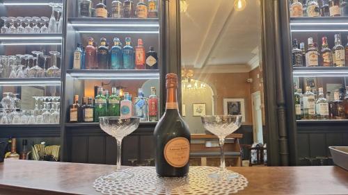 a bottle of wine sitting on a table with two glasses at East Walls Hotel in Chichester