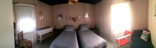 a bedroom with a bed and a dresser and a window at Charmante maison près de la mer in Asnelles