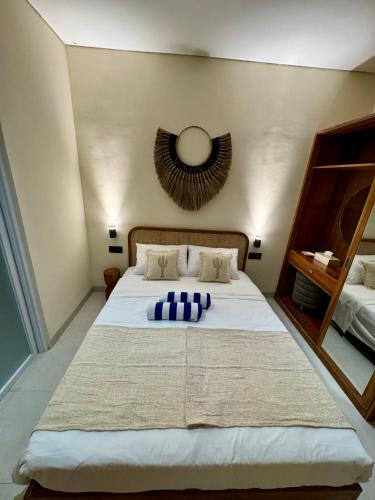 a bedroom with a large white bed with blue pillows at Casa Deva in Uluwatu