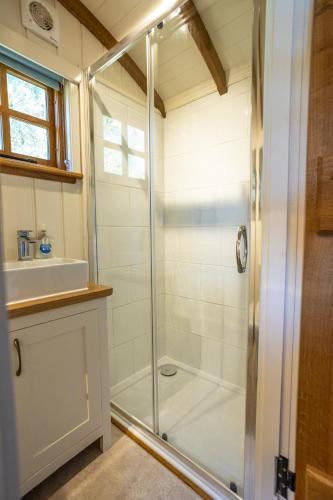 a bathroom with a shower and a sink at Luxury Glampsite with Sea Views in St Peter