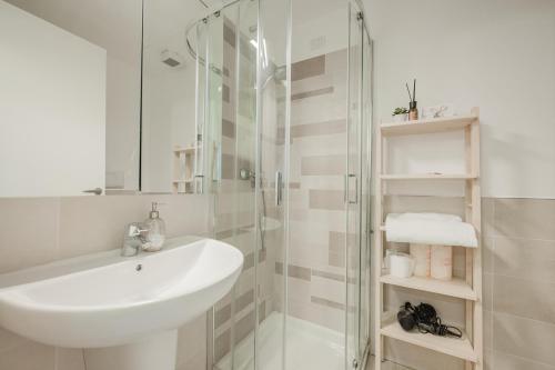 a white bathroom with a sink and a shower at Ca' Serena - Murano centro - 10 min from Venice in Venice