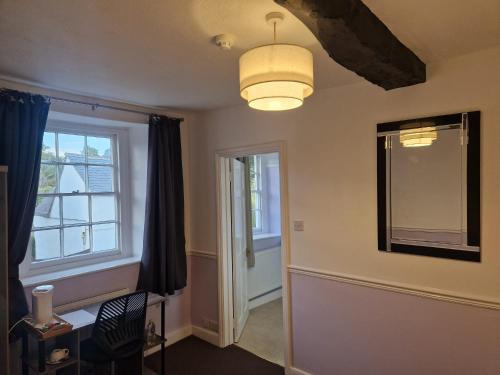 a living room with a table and a window at The Swan Hotel Oxford in Eynsham