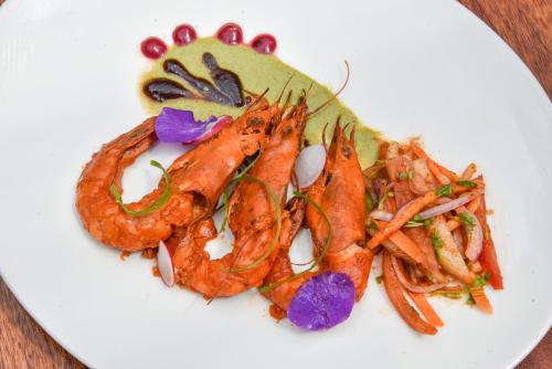 a white plate of food with shrimp and vegetables at Z Hotel & Z2 Hotel in Nungwi