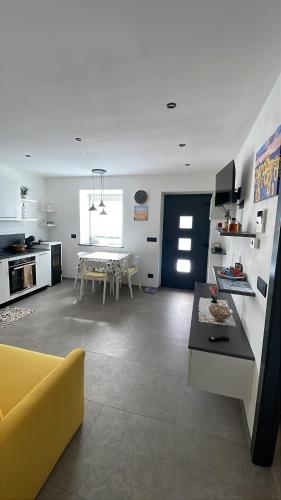 a living room with a yellow couch and a table at Appartamento Pineta casa vacanze Sci & Natura in Varena