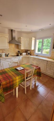 spacious villa في Saint-Vivien-de-Médoc: مطبخ به طاولة وطاولة وكراسي