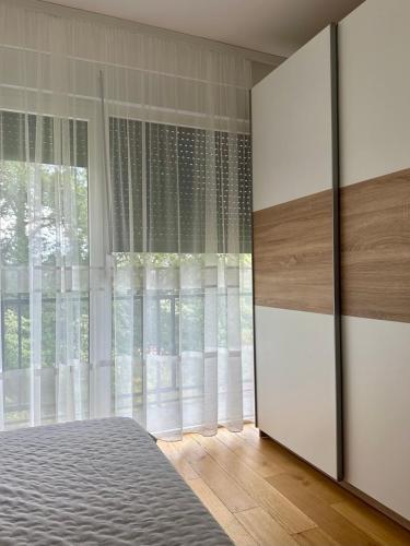 Un dormitorio con una cama y una ventana grande. en VIP House 4, en Vrnjačka Banja