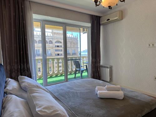 Un dormitorio con una cama con una ventana grande. en Luxury Sea View apartment by Bakuapart, en Baku