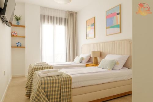 Un dormitorio con dos camas y una ventana en Casa de la Costa - Pintor Clemente, en Santiago de la Ribera